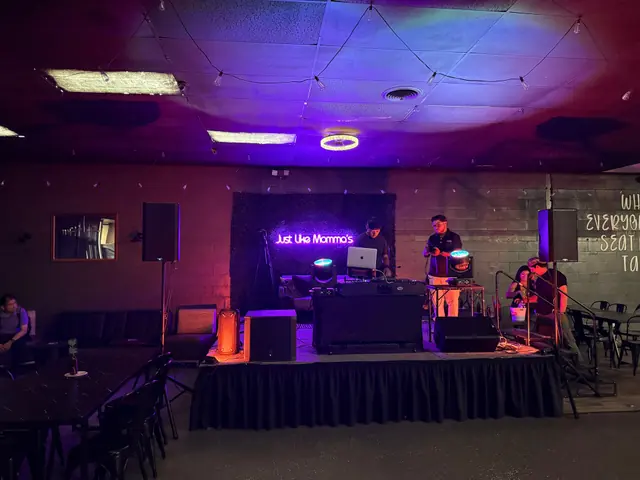 Speakers and colored lighting arranged around a small indoor stage